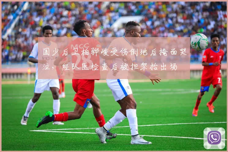 国少后卫柏骅峻受伤倒地后掩面哭泣，经队医检查后被担架抬出场